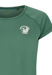 Camiseta verde de manga corta hecha de tejido suave, con cuello redondo y un estampado blanco con motivos de palmeras y "Protesta del Sol de la Gratitud".