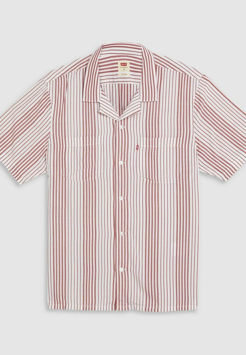 Camisa de manga corta en blanco con rayas verticales rojas. Presenta dos bolsillos frontales, un cuello con muescas y cierre de botones. Tejido ligero.