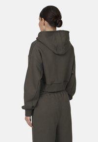 Geknipt hoodie in donkergroen, gemaakt van zachte stof met een trekkoordkap en gestikte details. Gemaakt in combinatie met bijpassende relaxed-fit joggers.