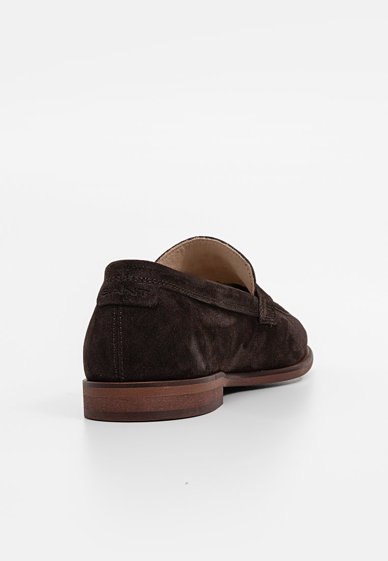 Braune Wildleder-Loafers mit niedrigem Absatz, runder Zehenform und dezentem Stickdetail an den Seiten.
