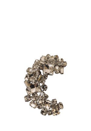 Cluster di pietre preziose chiare e sfaccettate disposte in una forma curva che ricorda la lettera C su sfondo bianco.