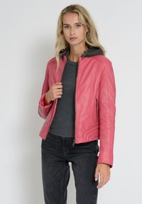 Rosa læderjakke med en tætsiddende design, lynlås-lukning og grå stofhætte. Har sidelommer og teksturerede detaljer på ærmerne.