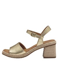 Gold metallic sandals with an open toe, ankle strap, and a woven jute block heel. Smooth texture and casual design.