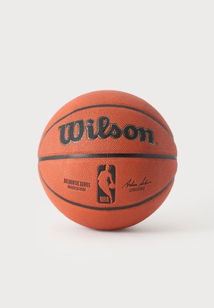 Ballon de basketball officiel orange Wilson NBA avec logo noir et signature sur un fond blanc uni.