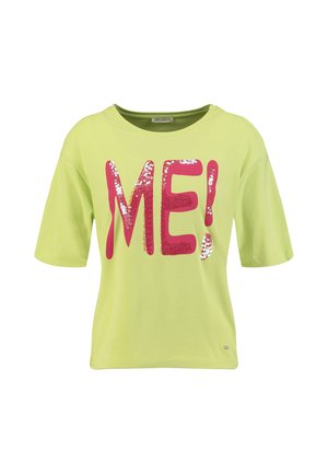 Chemise vert clair à manches courtes avec de grandes lettres roses en sequins formant "ME!" sur la poitrine.