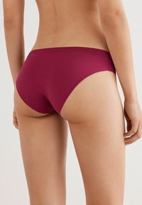 Burgundyröda bikiniunderdelar i bomullsblandning med lågt skär, sömlösa kanter och måttlig täckning bak. Slät textur och figursydd design.