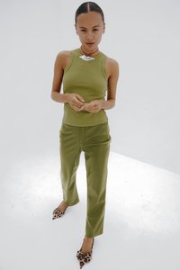Groene geribbelde tanktop en bijpassende hoog getailleerde broek, strakke pasvorm. Geaccentueerd met lederen hakken met luipaardprint. Glad, sleek stoftextuur.