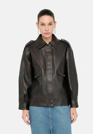 Giacca in pelle marrone con colletto, due tasche frontali, chiusure a pulsante e spalline. Ha una texture liscia e una vestibilità su misura.