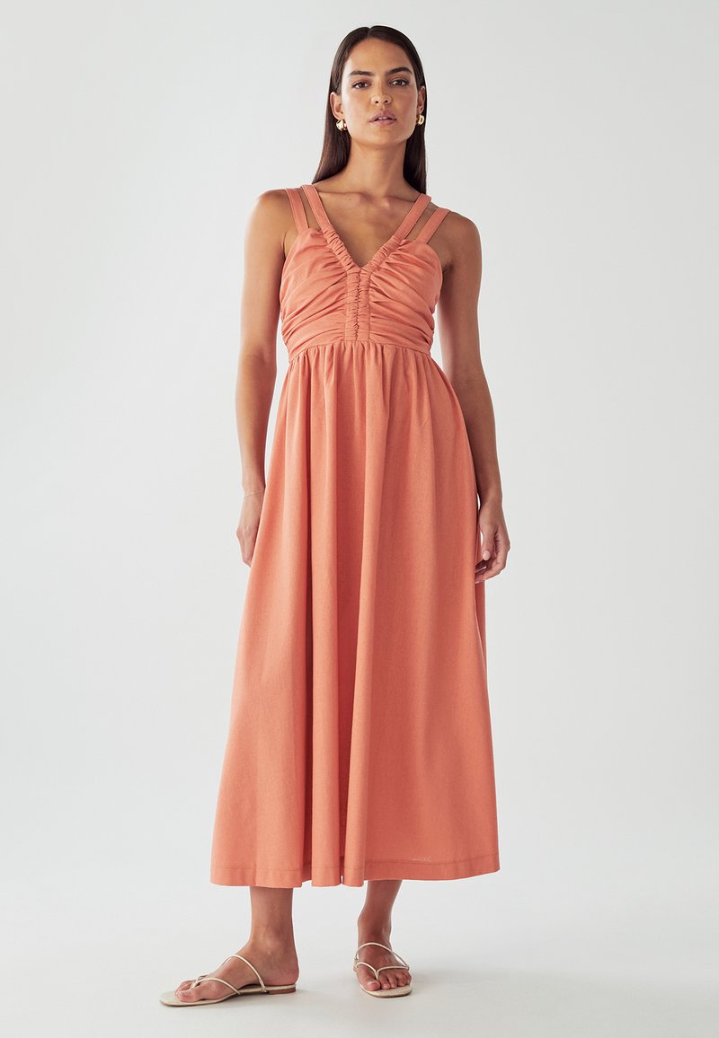 Korallivärvi maxi-kleit, millel on kroogitud detailid, vormitav piht ning laiad rihmad. Langen laiaks seelikuks, valmistatud kerge kangaga.