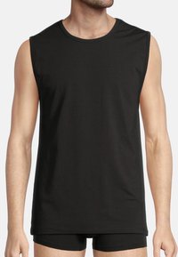 Black sleeveless t-shirt made of soft fabric, featuring a round neckline and a relaxed fit. Seamless construction with minimal detailing.