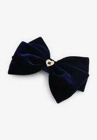 Fascia per capelli in velluto blu navy con un design testurizzato prominente, caratterizzata da un accento a forma di cuore dorato al centro.