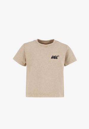 Camiseta de algodón beige con cuello redondo, mangas cortas y un pequeño logo negro impreso en el frente. La textura parece suave y lisa.