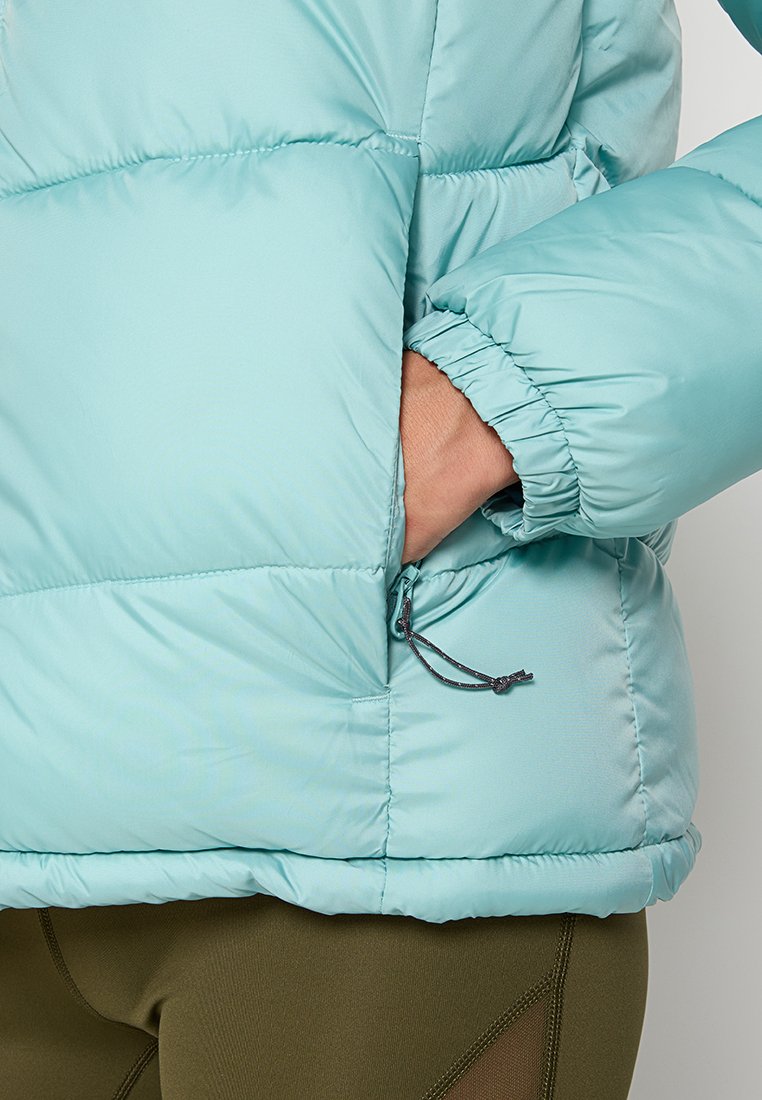 Chaqueta de plumas azul clara con puños elásticos y ajuste con cordón en el dobladillo. Textura suave y lisa con un diseño acolchado.