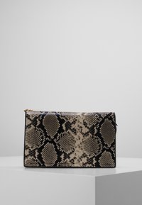 Sac à main avec un design en imitation serpent beige et noir, de forme rectangulaire, surface texturée, et une fermeture éclair dorée.