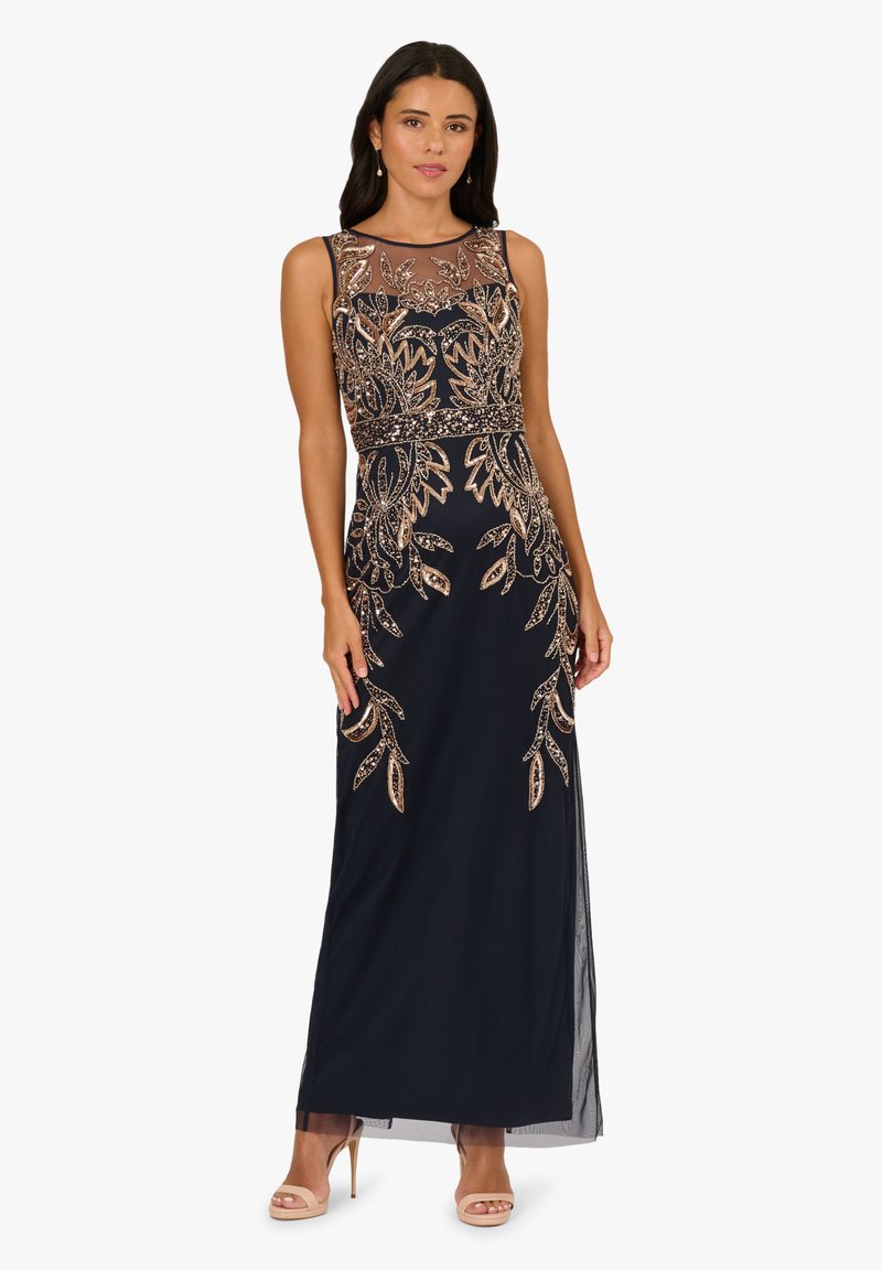 Marineblaue Abendkleid mit tailliertem Oberteil, durchsichtiger Halslinie und aufwendiger goldener Stickerei mit floralen Mustern. Fließender Rock mit transparenten Akzenten.