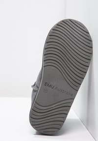 Szare zamszowe kapcie z teksturowaną gumową podeszwą w faliste wzory oraz logo EMU Australia. Wnętrze zapewnia komfort i ciepło.