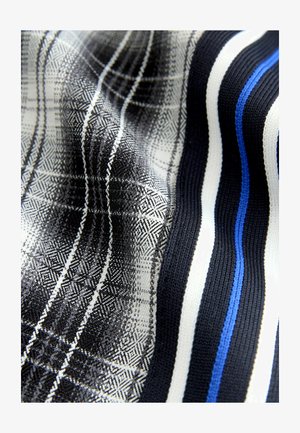 Szövet, amely fekete és fehér kockás mintáját a vibráló kék és fehér csíkokkal kontrasztálja, texturált felületet mutatva.