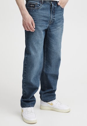 Blugi din denim albastru deschis cu croială dreptă, design cu cinci buzunare și închidere cu nasturi. Asortați cu adidași albi cu accente aurii.