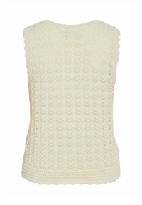 Top sin mangas de punto en color crema con un patrón texturizado y dobladillo con volante. Presenta un diseño de punto abierto y ribete acanalado en la parte inferior.
