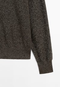 Knit sweater in dark brown with a textured pattern. Features a ribbed hem and cuffs. Sleeve extends fully without embellishments.