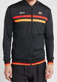Svart zip-up sportjacka med röda och orange horisontella ränder över bröstet och vid ärmsluten, ellesse-logotyp på vänster bröst.
