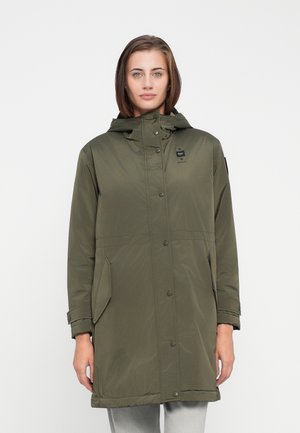 Veste rembourrée vert olive avec capuche, fermetures à pression, poches latérales et une étiquette sur la poitrine gauche. Tissu lisse et léger avec une finition mate.