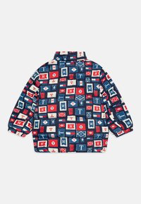 Polstret jakke med et fargerikt patchwork-design i rødt, blått og hvitt; har høy krage og elastiske mansjetter.