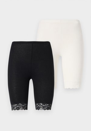 Black and white stretch shorts with lace detailing at the hems. The black pair features a floral lace pattern, while the white pair has solid trim.