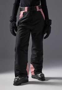 Black snow pants with pink side panels, equipped with a black belt, and worn with black ski boots. The fabric appears water-resistant.