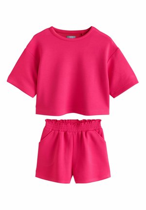Ensemble décontracté deux pièces rose vif avec un top court à manches courtes et un short à taille élastique avec des poches latérales.
