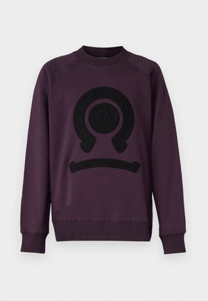 Purple sweatshirt with a round black logo on the front. Features a crew neck and ribbed cuffs and hem. Soft fabric texture.