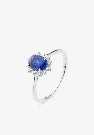 Weißgoldring mit einem zentralen ovalen blauen Saphir, umgeben von kleinen runden weißen Diamanten in einer floralen Clusterfassung.