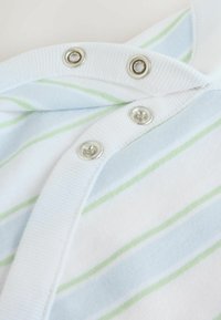 Tissu blanc avec des rayures bleu clair et vertes, fixé par des boutons-pression argentés le long d'un bord côtelé.