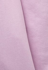 Gros plan sur un tissu violet clair plié, montrant une texture douce et un motif de tissage diagonal.