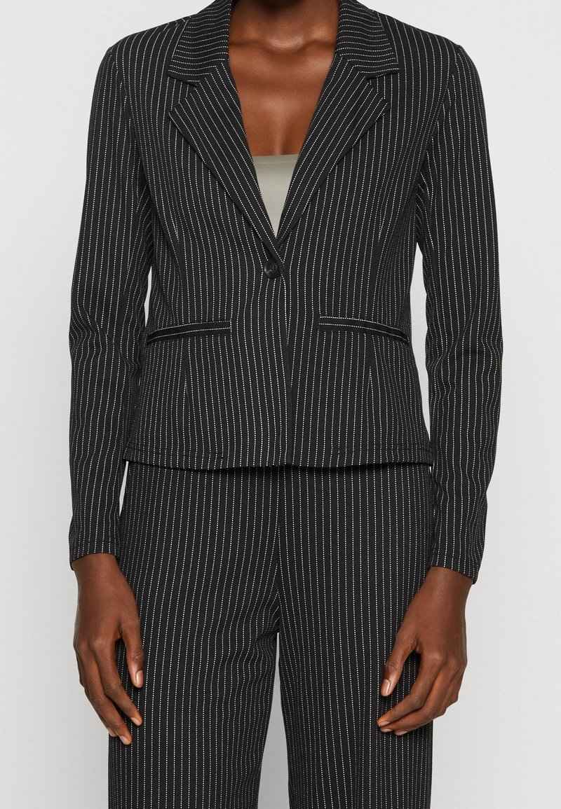 Czarny żakiet w prążki z wysmuklonym kołnierzem, zapięcie na jeden guzik, dwie przednie kieszenie, dopasowany krój i fakturowany materiał.