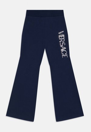 Pantaloni a gamba larga blu navy con vita elastica e logo "VERSACE" in strass bianchi sulla coscia destra.