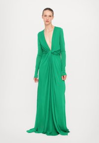Rochie verde cu maneci lungi, decolteu adânc în V, design drapat și detalii plie în talie, realizată dintr-un material moale și texturat.