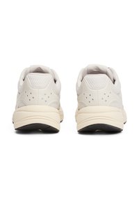 Baskets beige clair avec une tige en maille texturée, des semelles rembourrées et de subtiles perforations pour la ventilation. La semelle en caoutchouc offre une bonne adhérence.