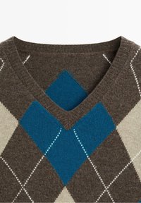 Pull marron à col en V avec un motif classique d'argyle comprenant de grands losanges bleus et beiges ainsi que des lignes blanches cousues.