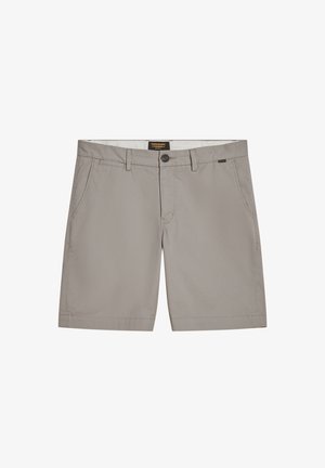 Pantaloni corti grigio chiaro realizzati in tessuto con una texture liscia, dotati di chiusura con bottone, tasche laterali e un'etichetta con il marchio in vita.