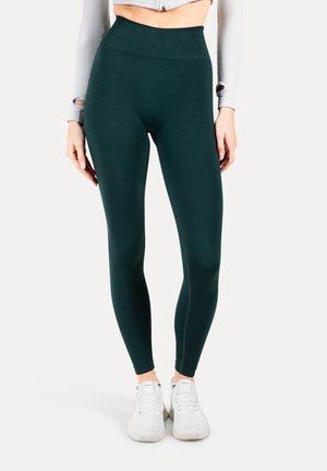 Hoge taille, aansluitende legging in donkergroen, gemaakt van een gladde, rekbare stof. Beschikt over een naadloos ontwerp en een zachte, brede tailleband.