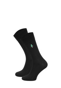 Czarne bawełniane skarpetki z prążkowanym mankietem i małym zielonym haftowanym wzorem choinki w pobliżu kostki.