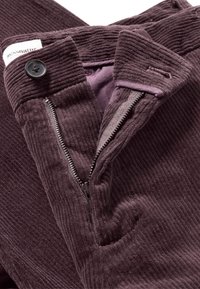 Corduroy broek in donkerpaars met een gestructureerd oppervlak, ritssluiting en een knop bij de tailleband. Voorzien van zakken en gestikte details.