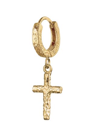 Boucle d'oreille créole texturée en or avec un petit pendentif croix en or à finition brute suspendu dessus sur fond blanc.