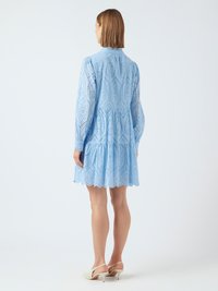 Ανοιχτό μπλε φόρεμα από ύφασμα μποντουάρ, με tiered σχέδιο, μακριά μανίκια και σκαλιστό άκρο. Ολοκληρώνουν την εμφάνιση κομψές σανδάλια με λεπτό τακούνι.