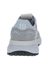 Sneaker atletica grigia con una tomaia in pelle liscia e suede, dotata di una suola bianca, dettagli testurizzati e il numero "19" sul tallone.