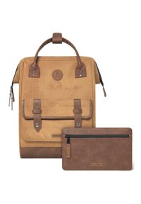 Sac à dos en toile beige avec des accents en cuir, poignée supérieure et rabat frontal. Comprend une pochette zippée marron assortie.