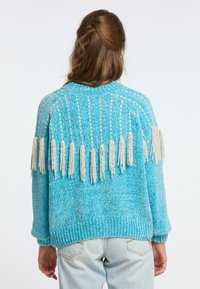 Maglione lavorato a maglia turchese con una finitura testurizzata, caratterizzato da frange color crema nella parte posteriore e polsini e orlo a coste.