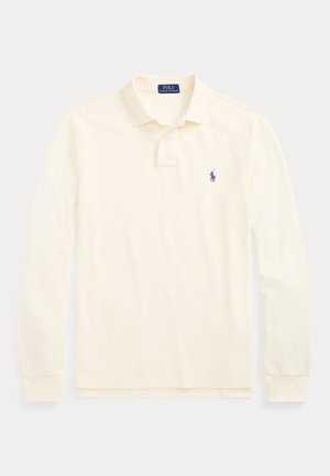 Krémová košeľa Polo Ralph Lauren s dlhým rukávom, golierom, dvojgombíkovou légou a malým tmavomodrým logom hráča póla na ľavej strane hrudníka.