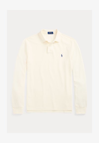 Κρεμ πουκάμισο Polo Ralph Lauren με μακριά μανίκια, γιακά, πατιλέτα με δύο κουμπιά και μικρό σκούρο μπλε λογότυπο παίκτη πόλο στο αριστερό στήθος.